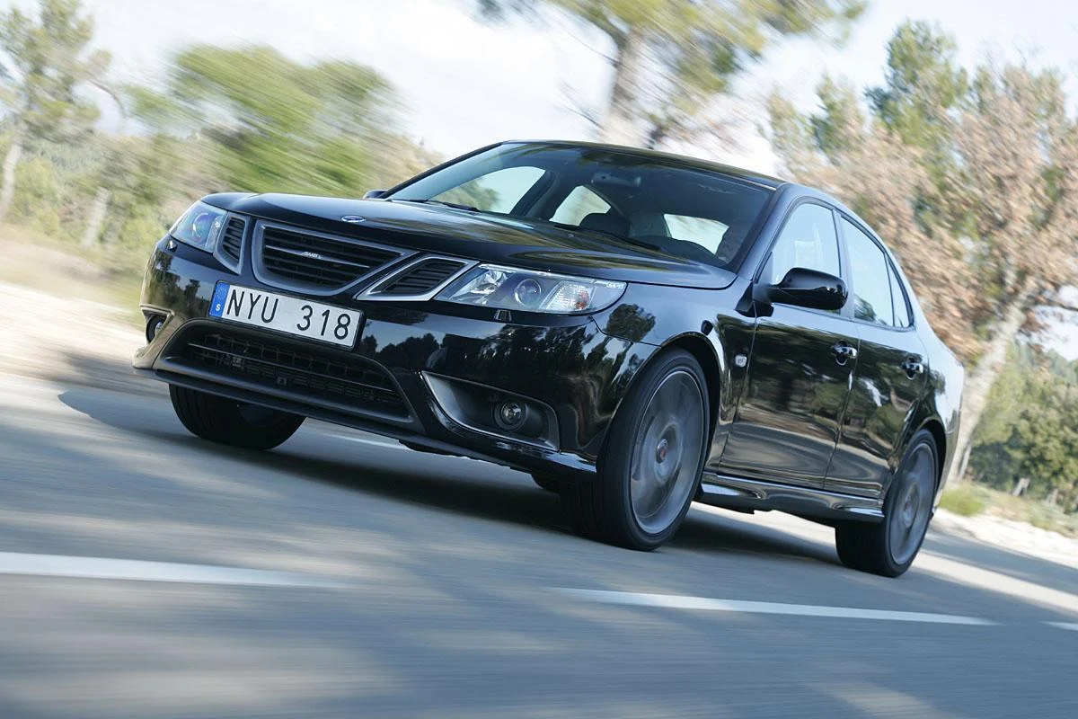 Black Saab Aero sedan driving on a road